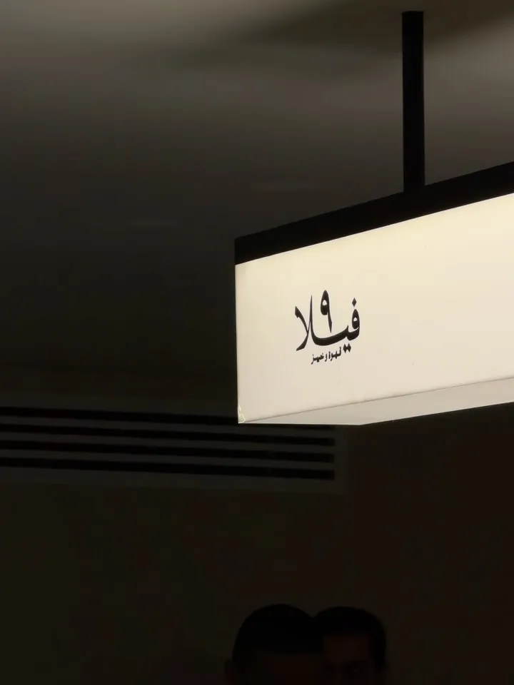 Close-up of the backlit sign reading فيلا ٩ with قهوة وخبيز beneath it.